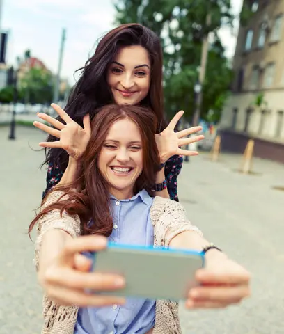 Cool Smiles Orthodontics - Two women smiling at cell phone